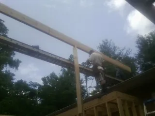 Carpenter setting a ridge beam over a new addition frame — Ice Dam Removal by Roofing Brothers in Mercersburg
