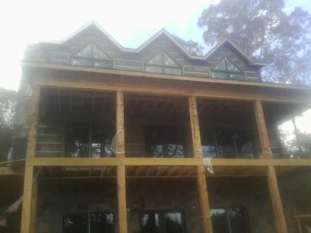 Dormers and porch framing on a large log home under construction — Roof Coating work by our crew in Mercersburg
