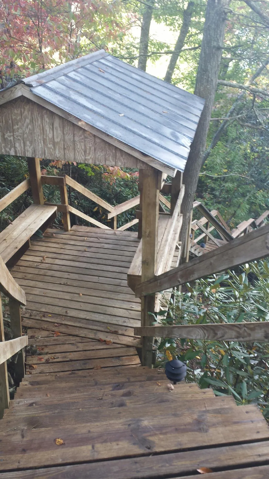 Metal roofed shelter over wooden steps on a wooded walkway — Skylight Repair & Installation work by our crew in Mercersburg